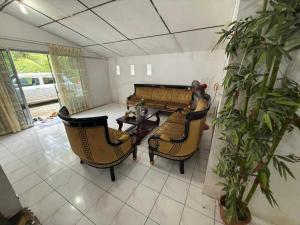 a living room with a couch and chairs and a table at OYO 91270 Sabsa Homestay in Kuching +18 photos
