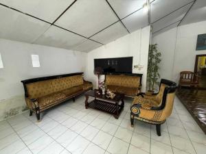 a living room with two couches and a table at OYO 91270 Sabsa Homestay in Kuching