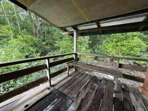a wooden bench sitting on a deck in the woods at OYO 91270 Sabsa Homestay in Kuching