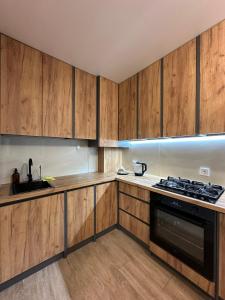 a kitchen with wooden cabinets and a stove top oven at ЖК Сонячна Тераса in Ternopil