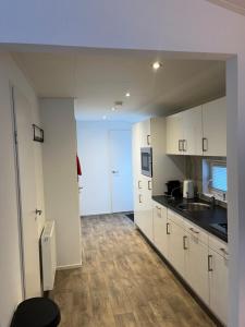 a kitchen with white cabinets and a counter top at Luxe Chalet Inn Otterlo op de Veluwe aan het Water! in Otterlo