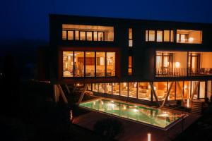 a building with a pool in front of it at night at Parkhotel Flora am Schluchsee in Schluchsee