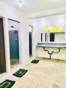 a bathroom with a sink and a desk and windows at Pilgrims Nature Villa in Ahangama