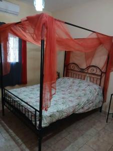 a bedroom with a bed with a canopy at Chez Andre in Ngaparou