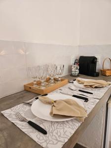 a table with plates and glasses on a counter at Casa Entre Coqueiros in Tamandaré