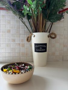 a bowl of candy next to a vase with a plant at B&B La Meta in Benevento