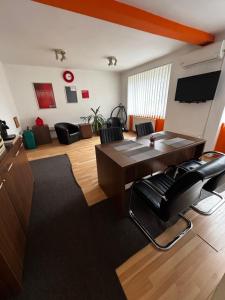 a living room with a wooden table and black chairs at LUMON Ultra Central Apartman in Târgu-Mureş