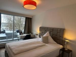 a bedroom with a large bed with a large window at Hotel Unterfeldhaus in Erkrath +87 photos