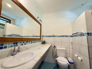 een badkamer met een wastafel, een toilet en een spiegel bij Recanto Verde Praia Hotel Juquehy in Juquei