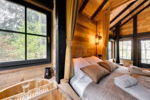a bedroom with a bed in a wooden cabin at Les cabanes des Dolimarts in Bohan