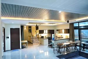 a living room and kitchen with a table and chairs at Luxe poolside farmhouse -J House in Hyderabad