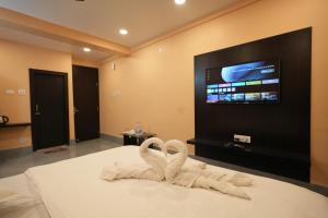 a bedroom with two swan towels on a bed at Hotel SagarPriya in Digha
