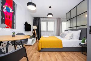 a bedroom with a bed and a table and a dining room at InPoint Smart Apartments in Krakow +41 photos