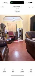 a living room with two couches and a living room with a couch at Bibi Cosy Cottage in Moshi