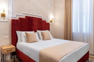 a bedroom with a large bed with a red headboard at Fiume 20 - Residence in Florence