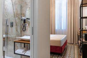 a bathroom with a shower and a bed and a sink at Fiume 20 - Residence in Florence +46 photos