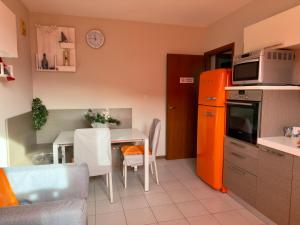 a kitchen with an orange refrigerator and a table at Maison della Presolana in Songavazzo