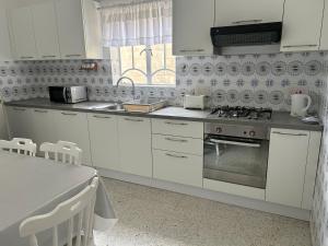 a kitchen with white cabinets and a stove top oven at Apartment in Żebbuġ Malta in Ħal Muxi