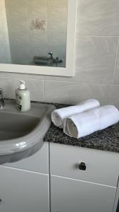a bathroom with a sink and a mirror and towels at Apartment in Żebbuġ Malta in Ħal Muxi +7 photos