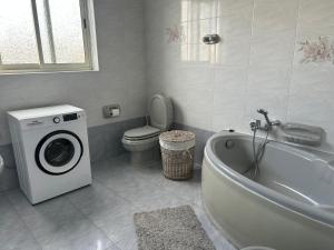 a bathroom with a washing machine and a bath tub at Apartment in Żebbuġ Malta in Ħal Muxi