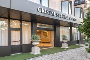 ein Gebäude mit zwei Topfpflanzen davor in der Unterkunft Hotel Cristal Setúbal in Setúbal
