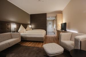 a hotel room with a bed and two couches at Parkhotel Flora am Schluchsee in Schluchsee