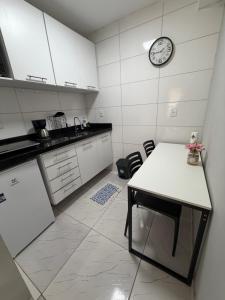 a kitchen with a table and a clock on the wall at AmazHost - Casa azul próxima da Basílica de Nazaré in Belém