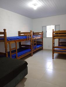 a room with three bunk beds and a kitchen at Chácara Mirante das Colinas in Atibaia