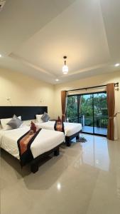 a bedroom with two beds and a large window at Serene Lanta Resort in Ko Lanta