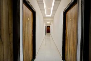 a hallway with two wooden doors and a long corridor at Via Blissful Stays in Mumbai