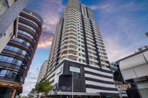 a tall building in the middle of a city at Darwin Central Escape Hotel Style Apartment with Kitchen , Pool , Gym , Car Park,Balconey in Darwin