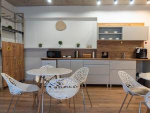 a kitchen with a white table and chairs at HM Apartments in Prešov