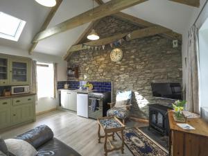 a kitchen and living room with a stone wall at Sgubor Delyn Aberystwyth in Llanrhystyd