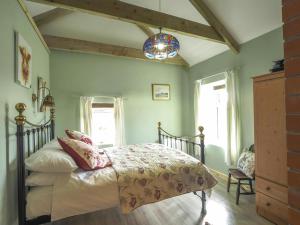 a bedroom with a bed with pink and white sheets at Sgubor Delyn Aberystwyth in Llanrhystyd