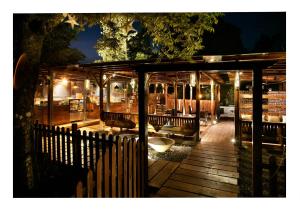 a wooden deck with benches and a fence at night at Hotel Malas in Panchgani