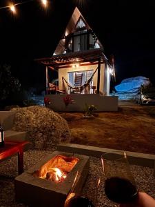 a fire pit in front of a house at night at Chale Gameleiras in Monte das Gameleiras