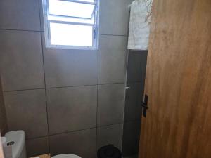 a bathroom with a toilet and a window at Casa Container Rosa in Bagé