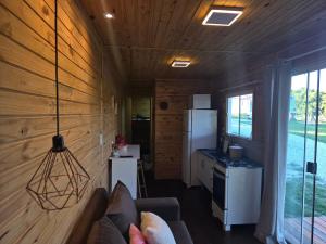 a kitchen with a couch in a tiny house at Casa Container Rosa in Bagé