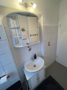 a white bathroom with a sink and a mirror at Ferienwohnung Emma in Castrop-Rauxel +37 photos
