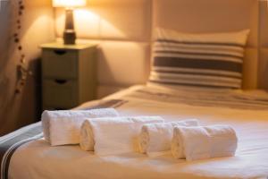 a group of three rolls of towels on a bed at Positano Apartment in Głowno