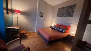a bedroom with a bed and a table with a lamp at Le Clos'art in Vinassan +33 photos
