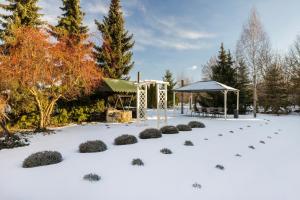a garden in the snow with a gazebo at Positano Apartment in Głowno