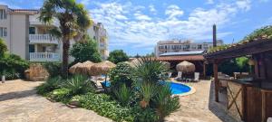 a resort with a swimming pool and a building at Family hotel Tropicana in Ravda