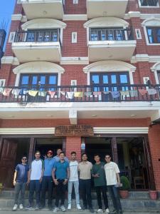 a group of men standing in front of a building at Hotel small town guest house in Bandipur