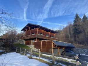 a large wooden house with a car parked in front of it at Little Chalet Piguet in Gryon