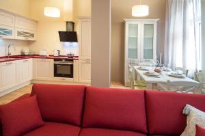プラハにあるApartment Za Poricskou branouのリビングルーム(赤いソファ付)、キッチン