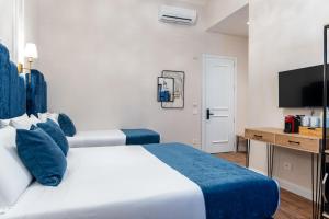 a bedroom with two beds and a desk and a television at Fiume 20 - Residence in Florence