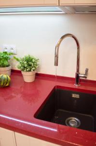 a kitchen sink with a red counter top at Apartment Za Poricskou branou in Prague