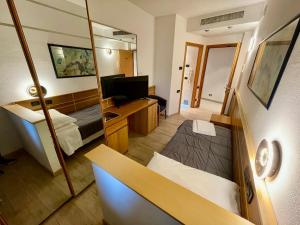 a small room with a bed and a mirror at Hotel Oasi Este in Este