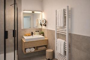 a bathroom with a sink and a mirror at BEELiving Augsburg in Augsburg